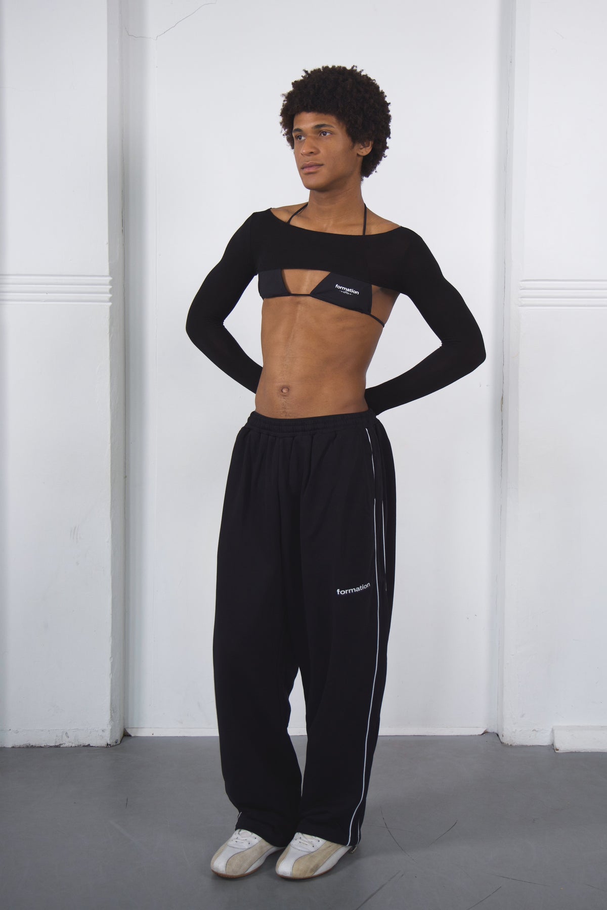 Person wearing a black dance outfit on a white background