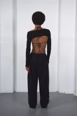 Person wearing a black dance outfit with cut-out design on a white background