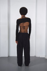 Person wearing a black dance outfit with cut-out design on a white background