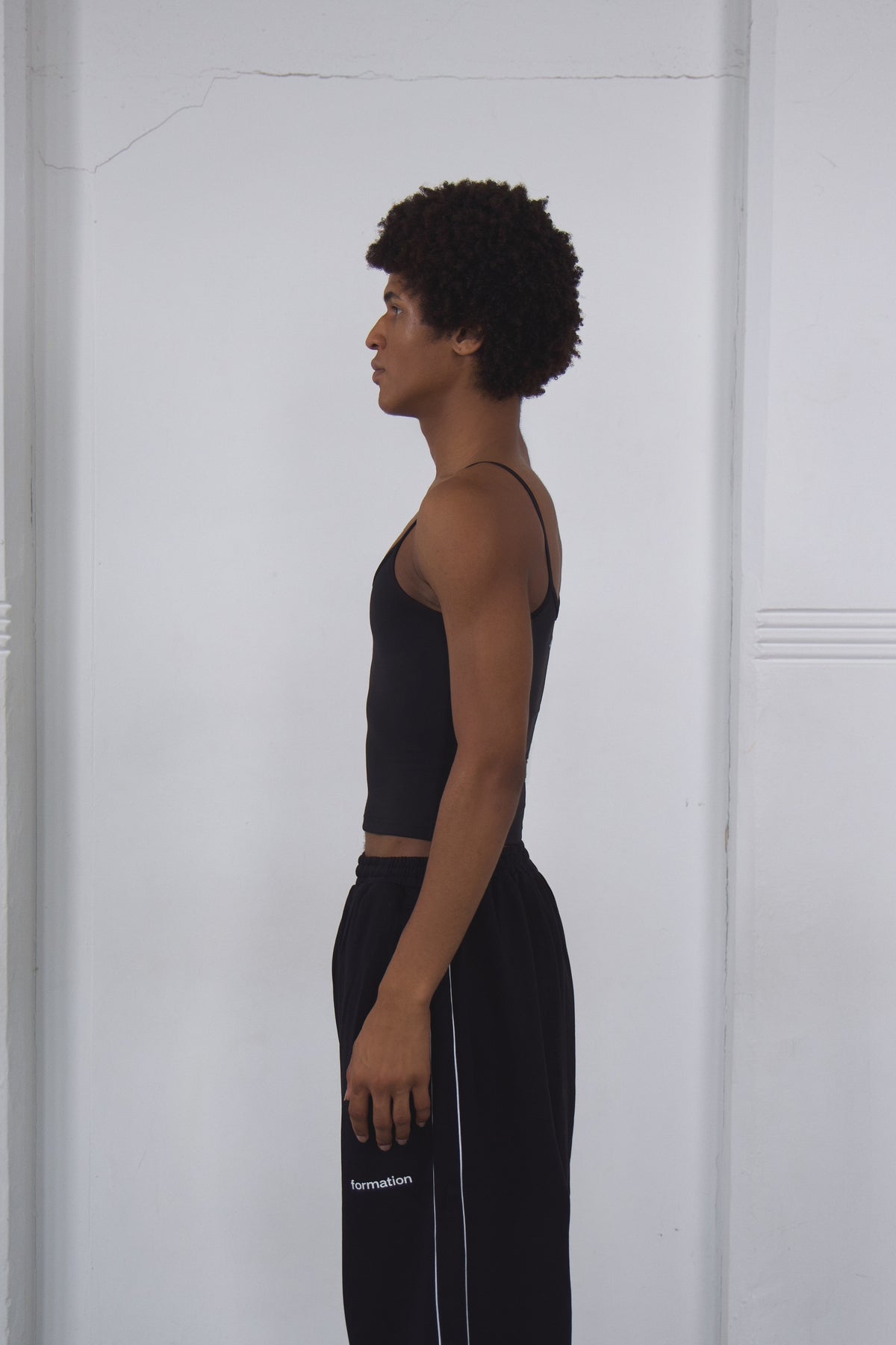 Person wearing a black outfit with white text on a white background