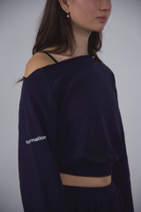 Person wearing a navy blue off-shoulder top with 'formation' text on a plain background